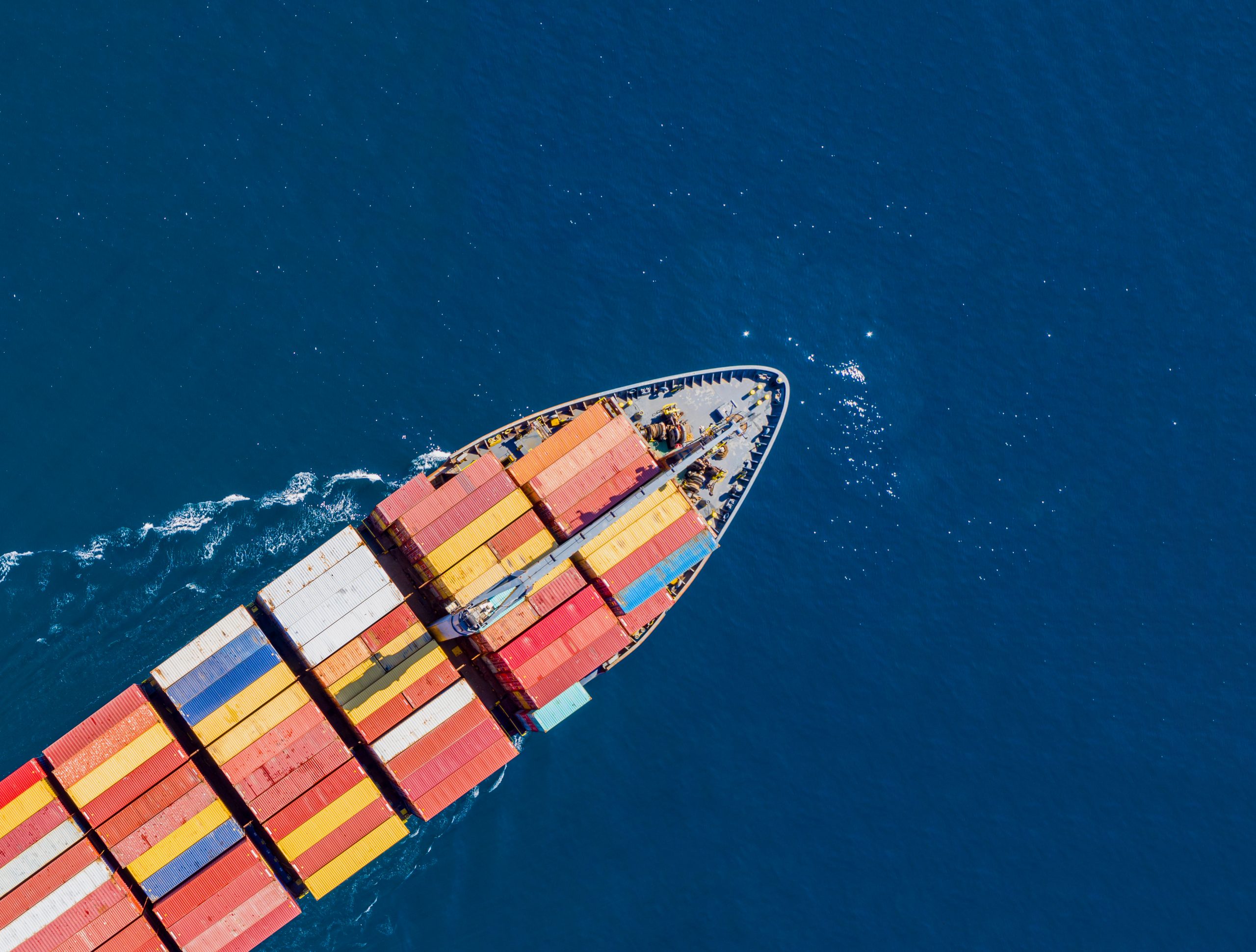 Container cargo ship, import export business and logistics, aerial top view. Water transport, international freight shipping, commercial trade and transportation in the open sea